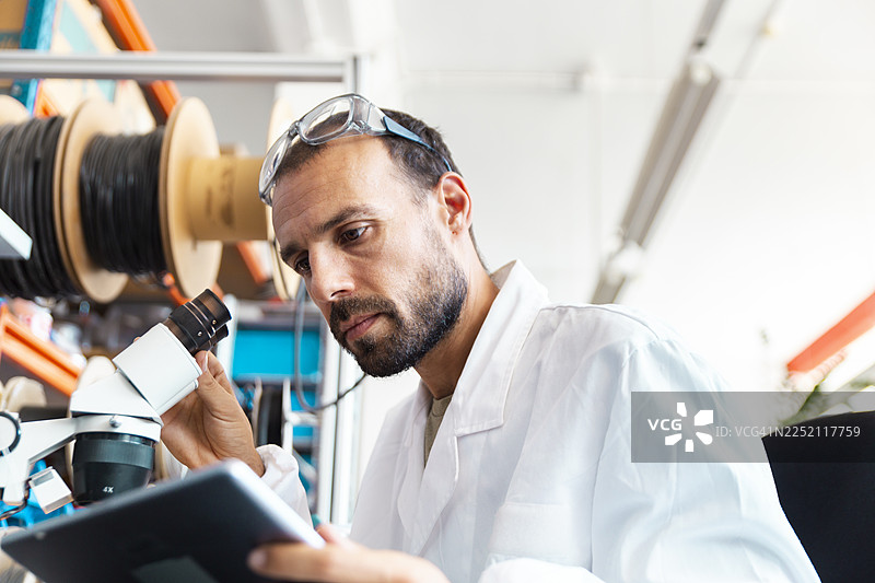 实验室技术人员在电子车间用放大镜检查微芯片图片素材