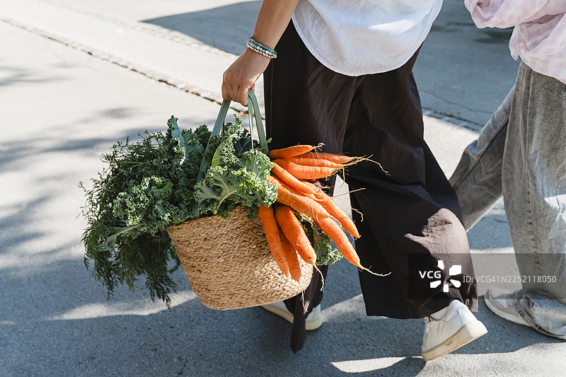 一位女士和她的女儿在户外用草篮子提着有机食品杂货图片素材