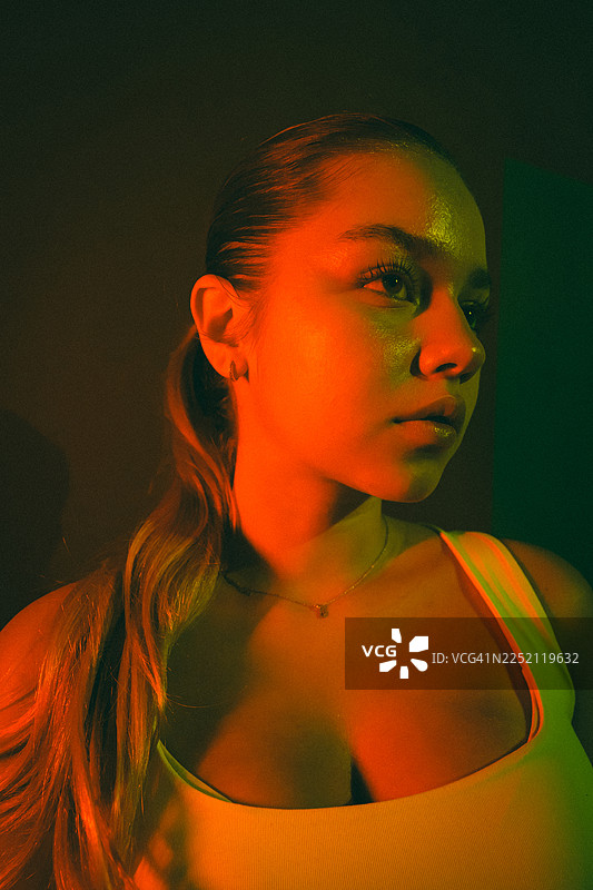 富有艺术感的都市风格，年轻女子在多彩霓虹灯光下的肖像图片素材