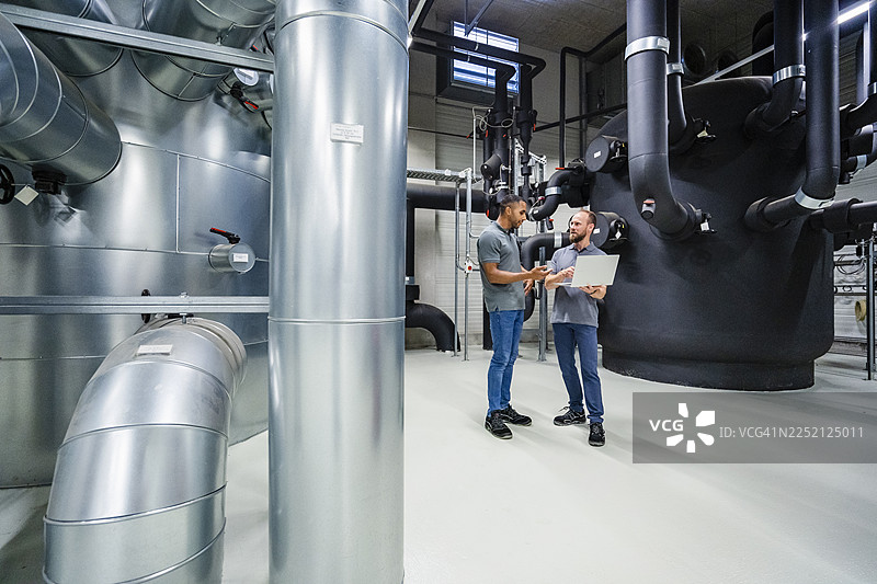 两位员工在工厂使用笔记本电脑图片素材