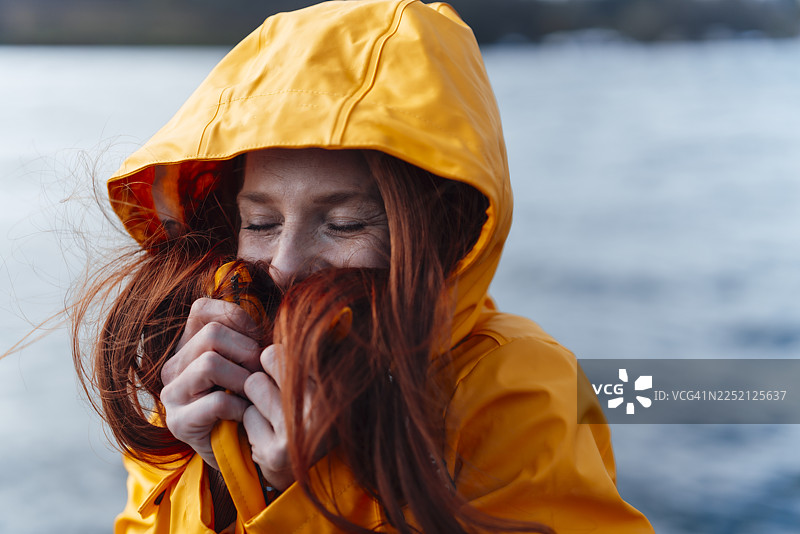 穿着黄色夹克的红发女子图片素材
