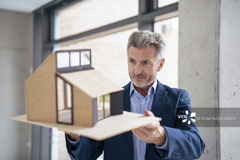 经验丰富的建筑师在办公室里审视房屋模型图片素材
