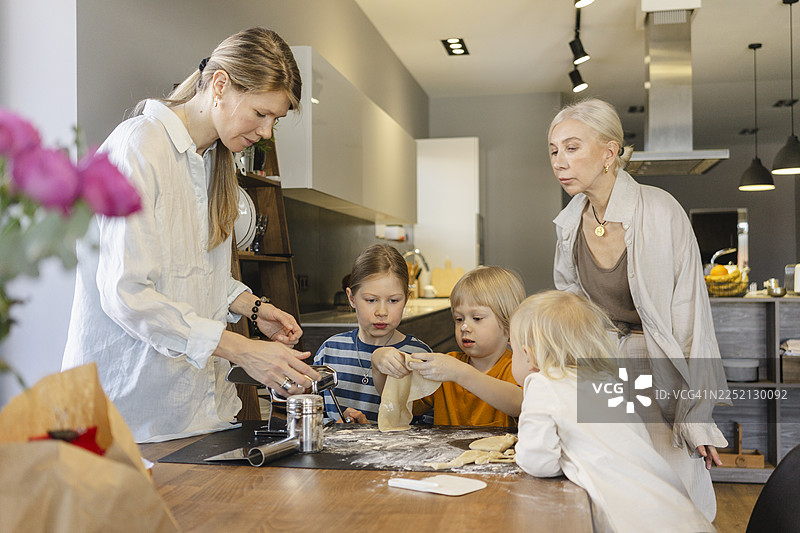 一家人在餐桌上一起准备意大利面团图片素材