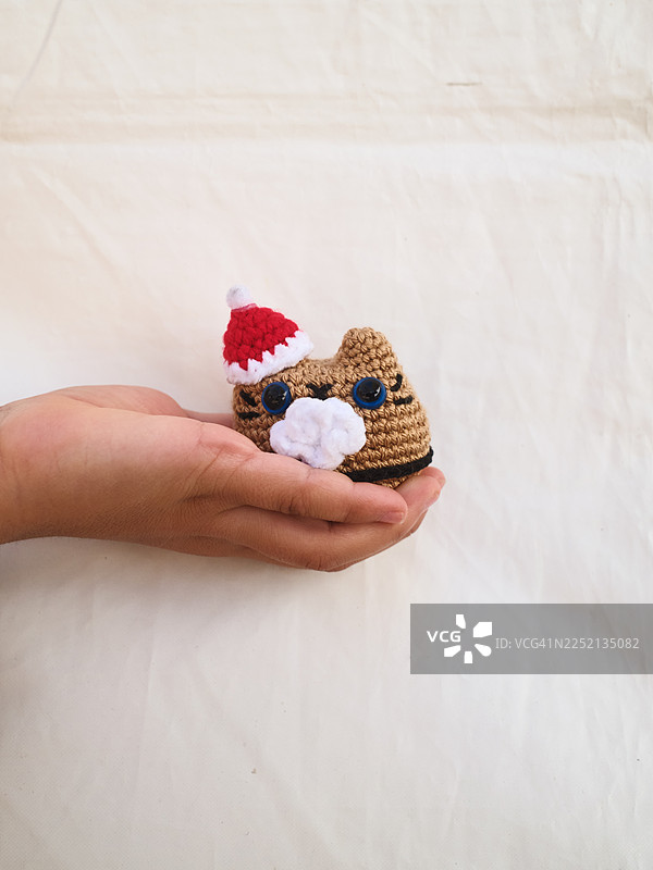 手持手工钩针编织的阿米巴猫玩偶圣诞玩具图片素材