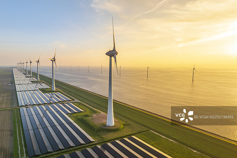 湖畔的风力涡轮机和太阳能电池板图片素材