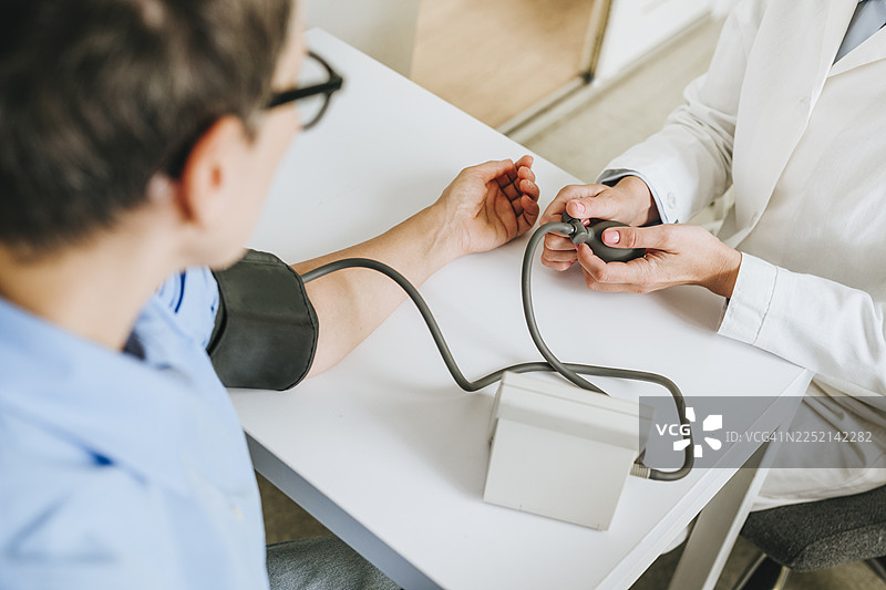 药剂师在药房为顾客测量血压图片素材