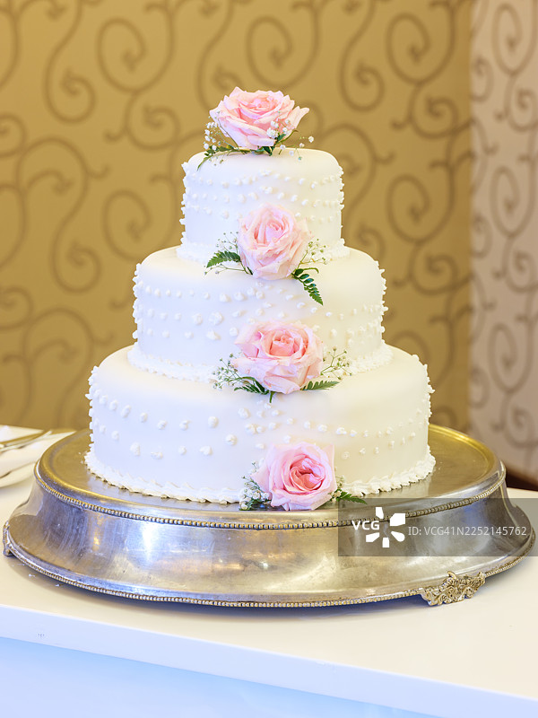 接待处的白色婚礼蛋糕配粉色玫瑰图片素材