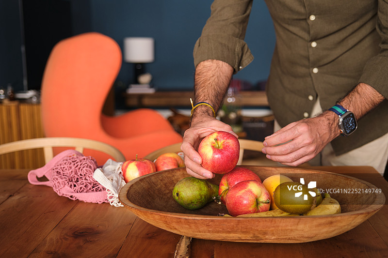 一个人在家里的木碗里摆放新鲜水果图片素材