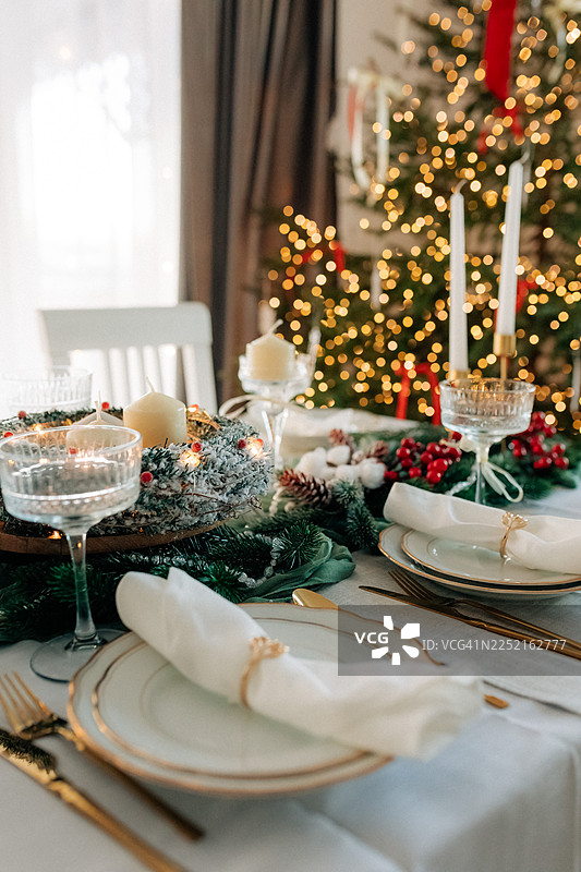 优雅的圣诞晚宴餐桌，饰有节日装饰和水晶玻璃杯图片素材
