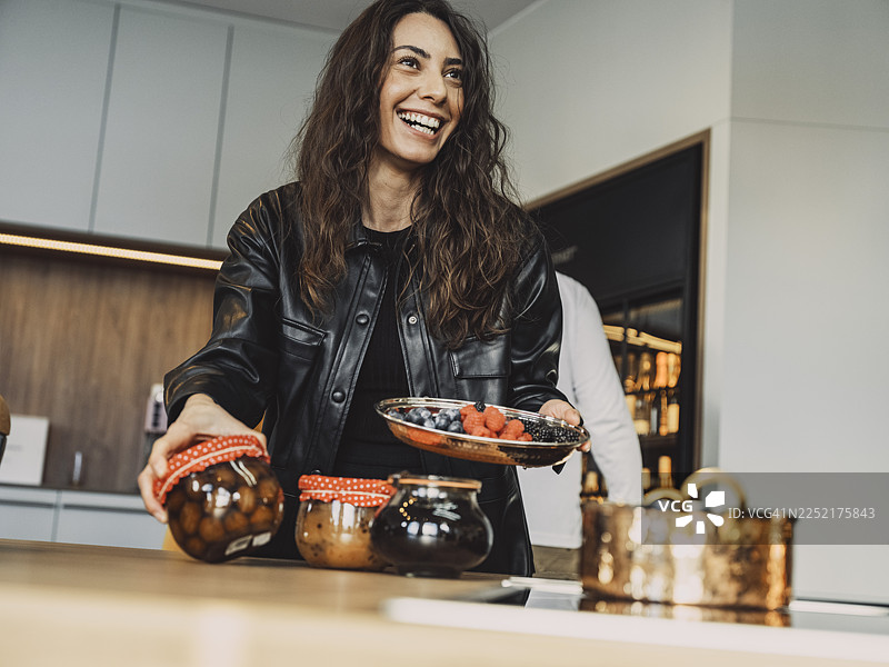 烹饪课学员在厨房里微笑着制作水果罐头图片素材