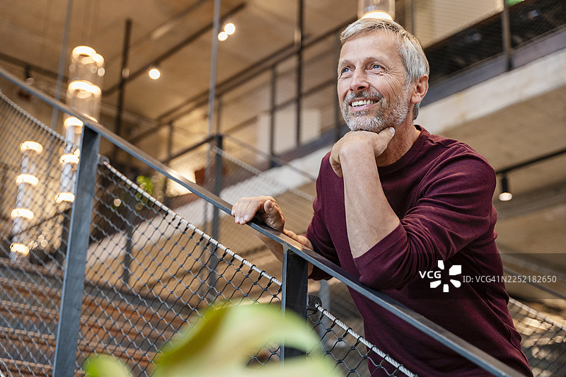 现代办公室室内，楼梯上商务男士的肖像照图片素材
