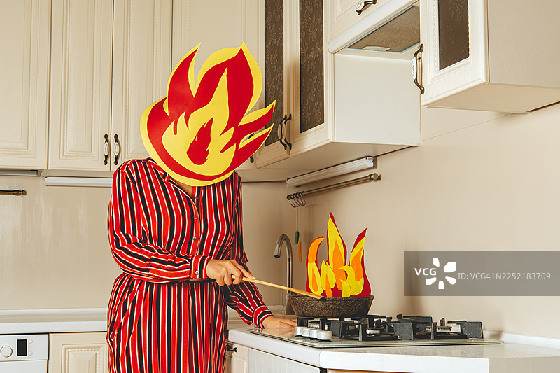 穿着条纹连衣裙的家庭主妇戴着防毒面具在厨房里幽默地烹饪图片素材