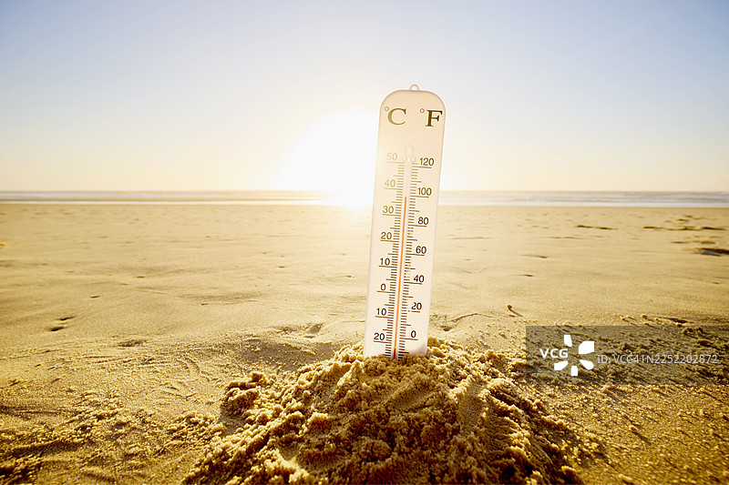 沙滩上城堡里的温度计，背景是阳光、大海和天空图片素材