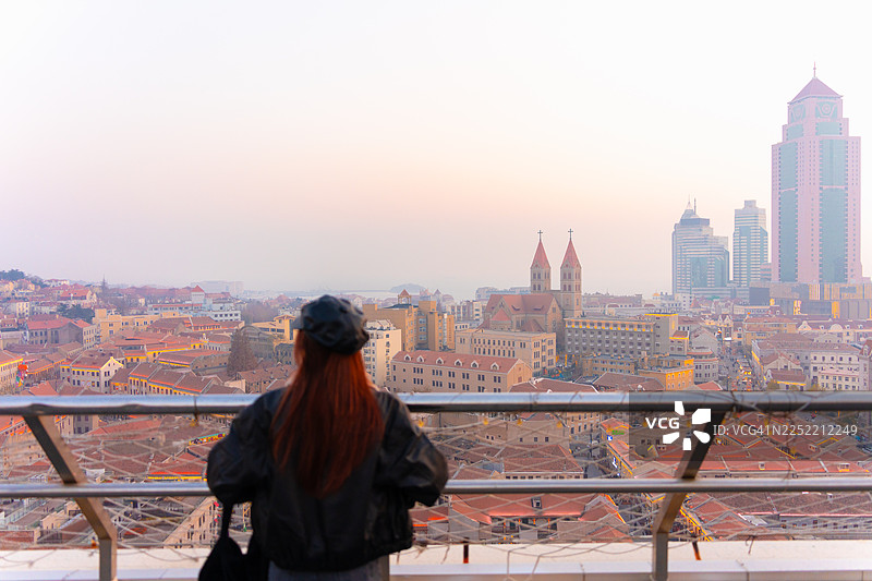 一位美丽的女子在黄昏时分探索中国青岛的圣迈克尔大教堂图片素材