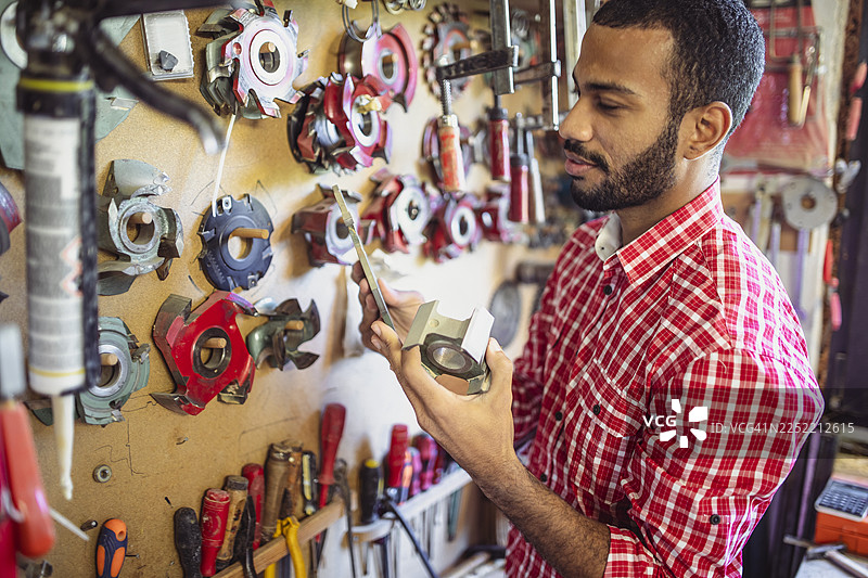 中年多民族男性木匠正在整理工作室的工具图片素材