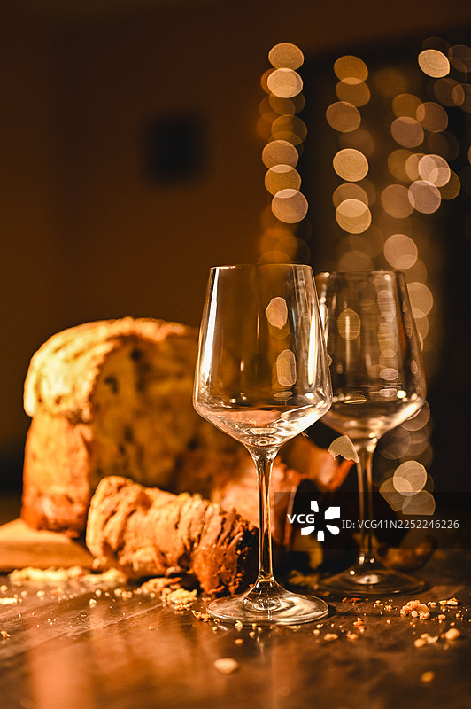 圣诞意式面包配空酒杯和节日灯光图片素材