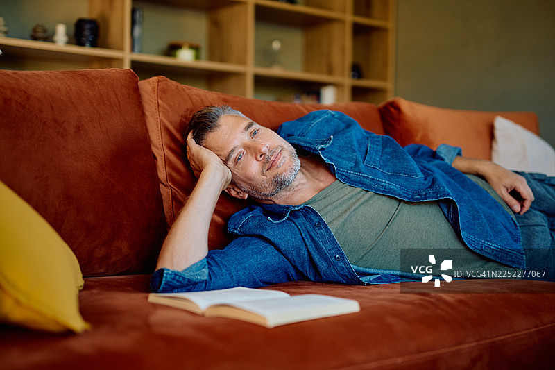 男人在闲暇时光放松地躺在沙发上沉思图片素材