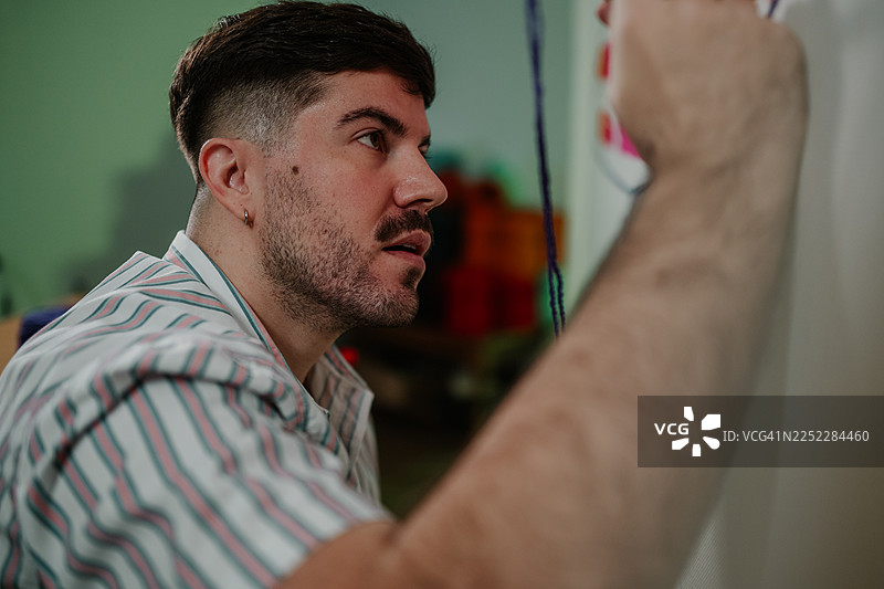 年轻成年男子专注于创意绘画项目图片素材