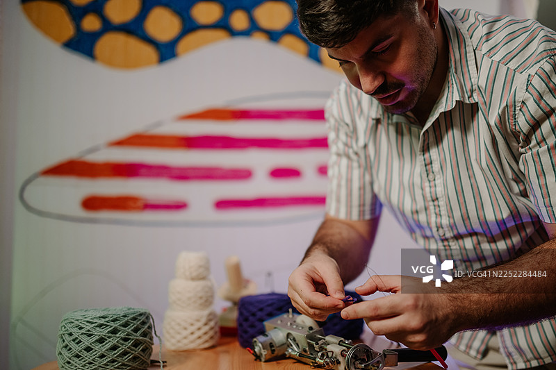 艺术家正在仔细地用纱线准备簇绒枪图片素材