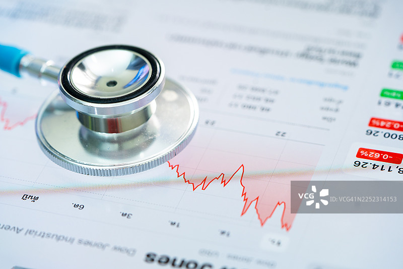 听诊器放在图表或图形上，金融、账户、统计和商业数据医疗健康。图片素材