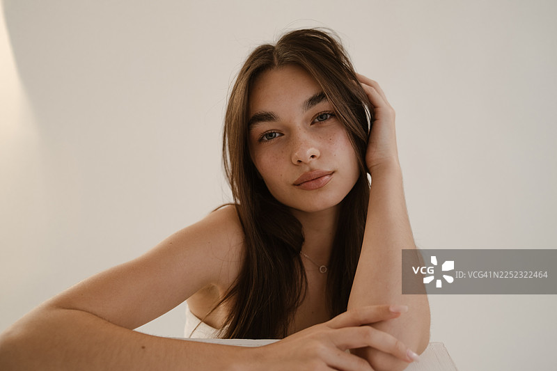 阳光下，一位拥有洁净水润肌肤的女性的特写肖像图片素材