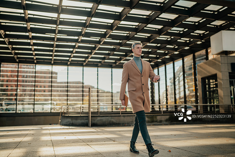 一个男人走在柏林波茨坦广场，在阳光明媚的日子里享受着充满活力的城市氛围图片素材