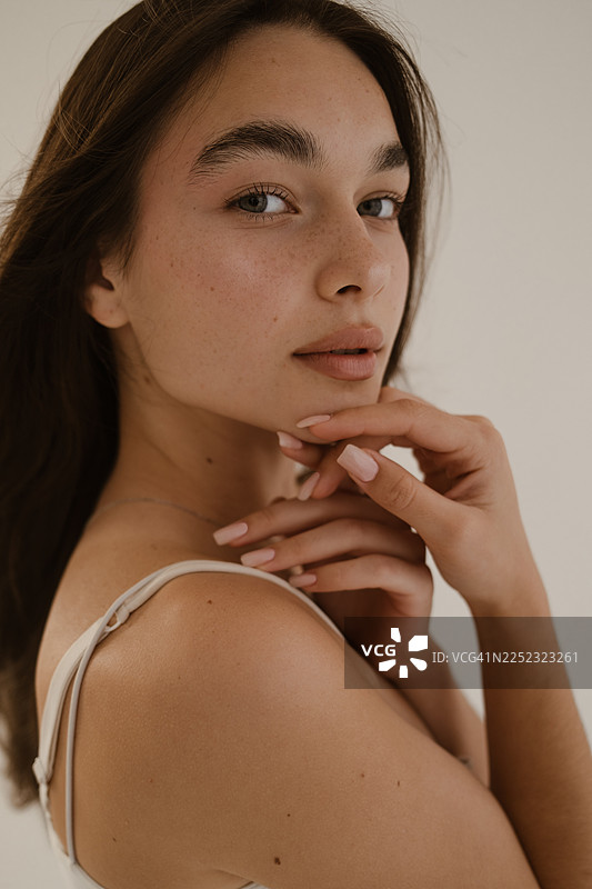 阳光下，一位皮肤洁净湿润的女性的特写肖像图片素材