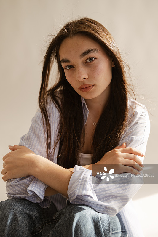 阳光下，一位皮肤洁净水润的女性的特写肖像图片素材