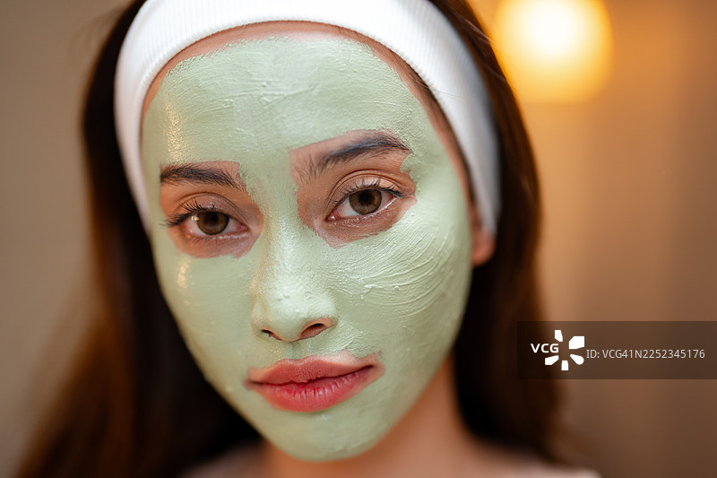 年轻女子在家制作有机面膜，在小碗中混合天然成分图片素材