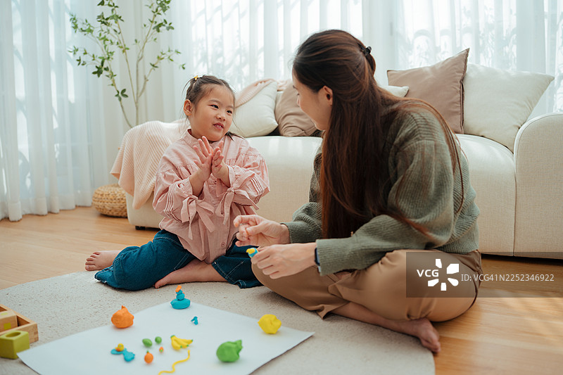 女儿和妈妈一起捏制彩色黏土的特写镜头图片素材