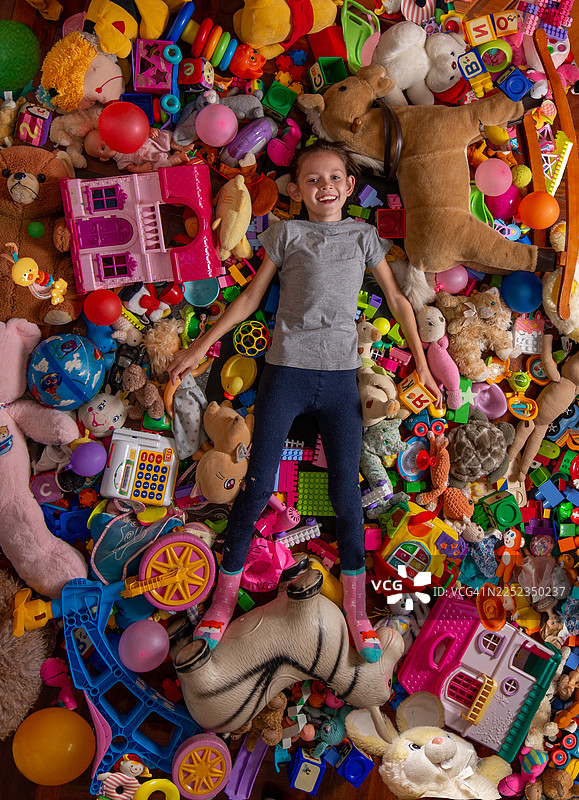 俯视，一个快乐的孩子和散落在地板上的玩具图片素材