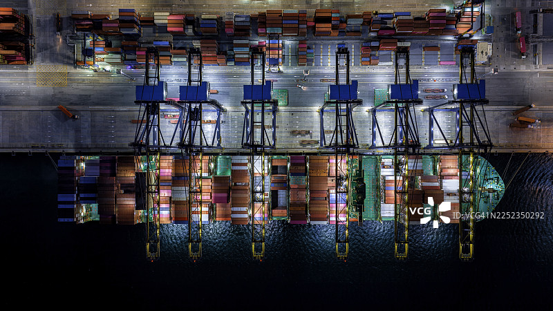 夜间作业的集装箱船的航拍俯视图。图片素材