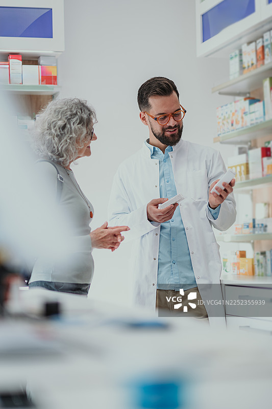 药剂师在药房指导老年女性用药图片素材