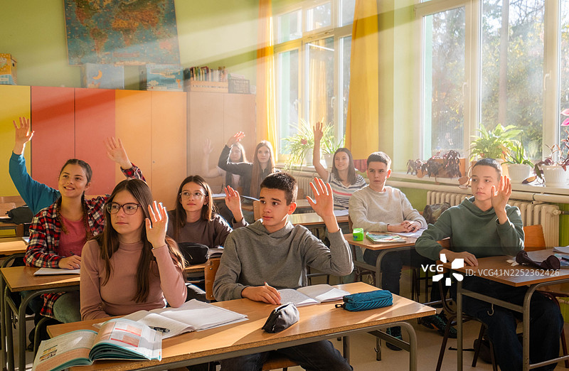 学生们积极参与课堂教学，举手示意图片素材