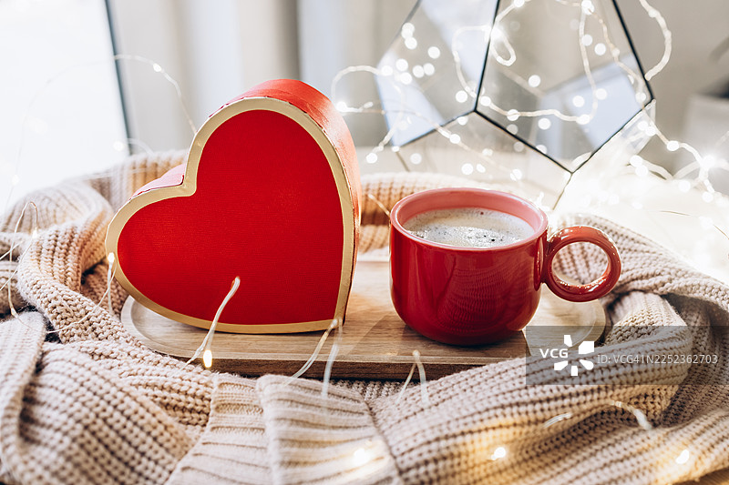 温馨的爱之晨：心形礼品盒、咖啡和串灯图片素材