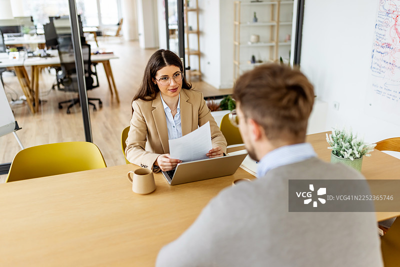 职业女性在现代开放式办公环境中与同事举行商务会议图片素材