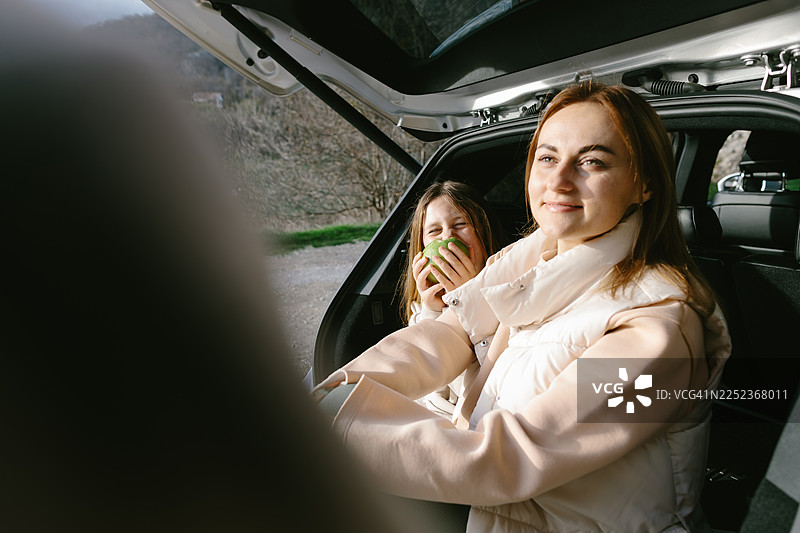 一家人在公路旅行休息时，在汽车后备箱里休息图片素材