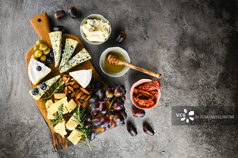 奶酪拼盘，盛有各种精选奶酪和葡萄，俯视视角图片素材