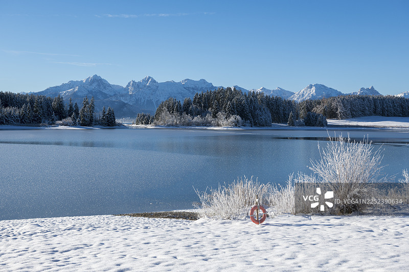 蓝天下，背景是雪山，位于德国巴伐利亚州阿尔高地区奥斯特阿尔高县菲尔根湖畔的罗森豪普滕附近图片素材