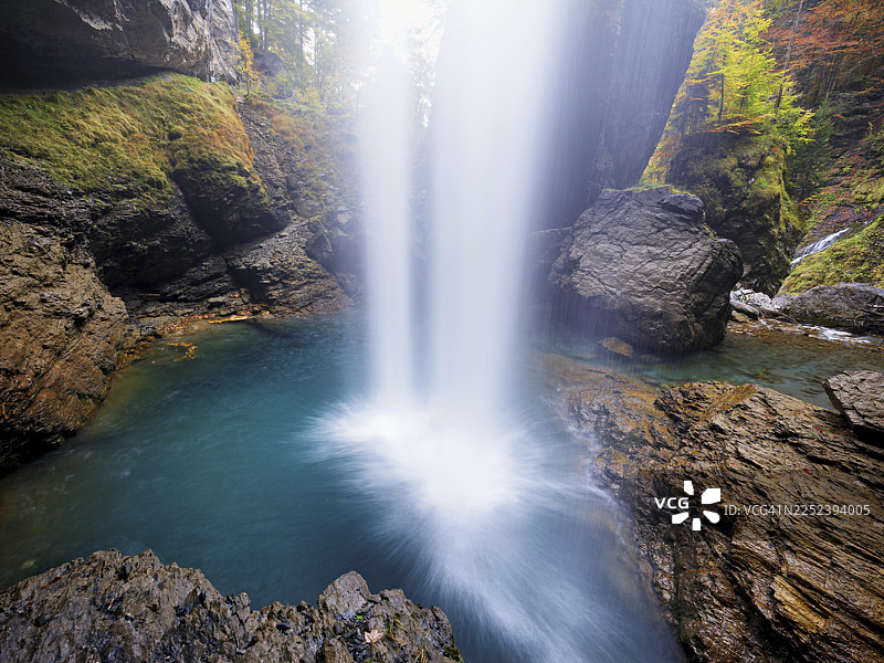 秋季色彩环绕的瀑布山峦，位于瑞士格拉鲁斯州克劳森山口的林塔尔图片素材