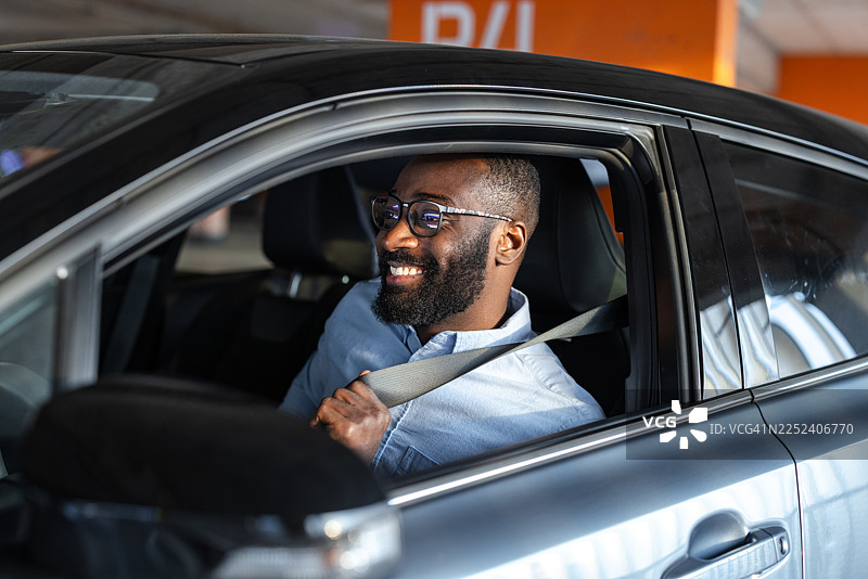 男人在现代汽车内系好安全带，为安全驾驶做准备图片素材