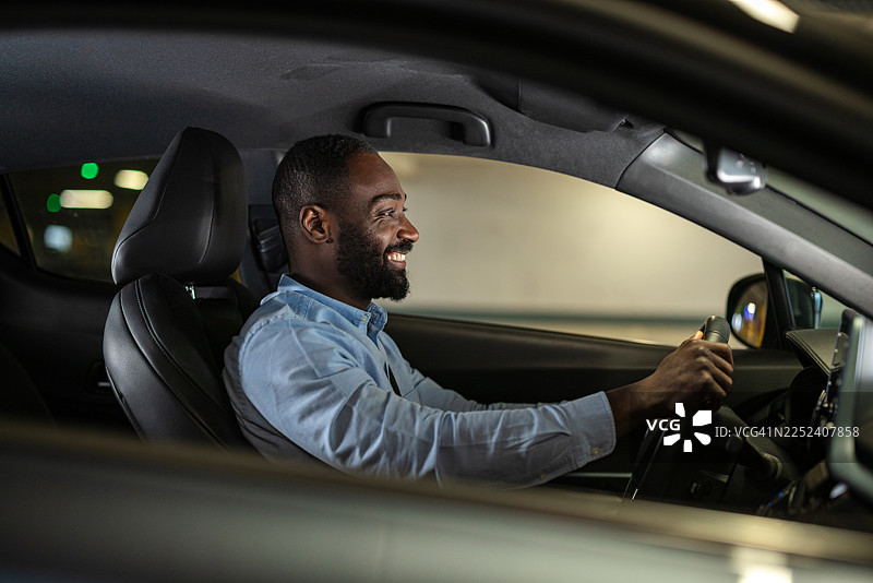 微笑的男人正在驾驶汽车，享受着现代车辆的通勤时光图片素材
