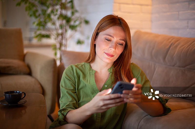 女子在家放松使用手机社交媒体图片素材