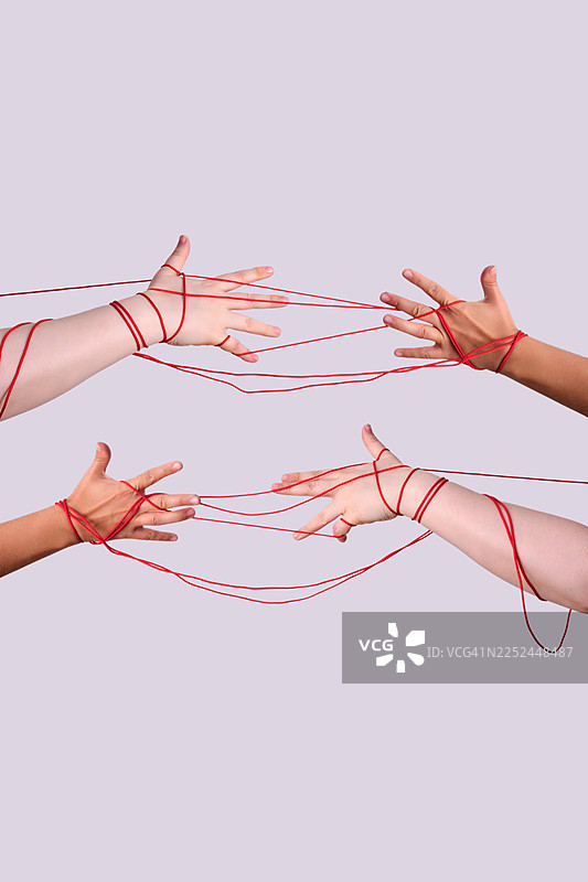 四只手由红线相连，背景为浅色，象征着连接与关系图片素材