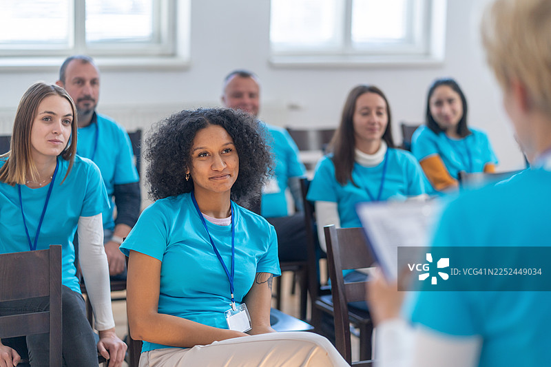 志愿者在会议室里专注地听取简报图片素材