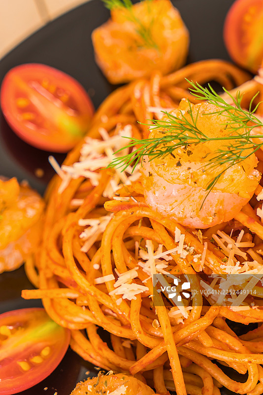 黑盘上美味的鲜虾番茄芝士意面特写，准备享用图片素材