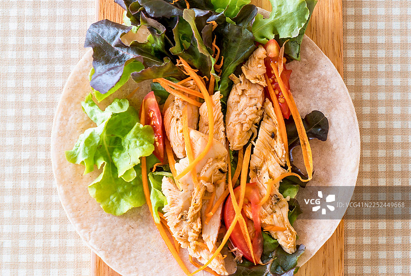 格子桌布上美味的鸡肉蔬菜卷，俯视角度图片素材