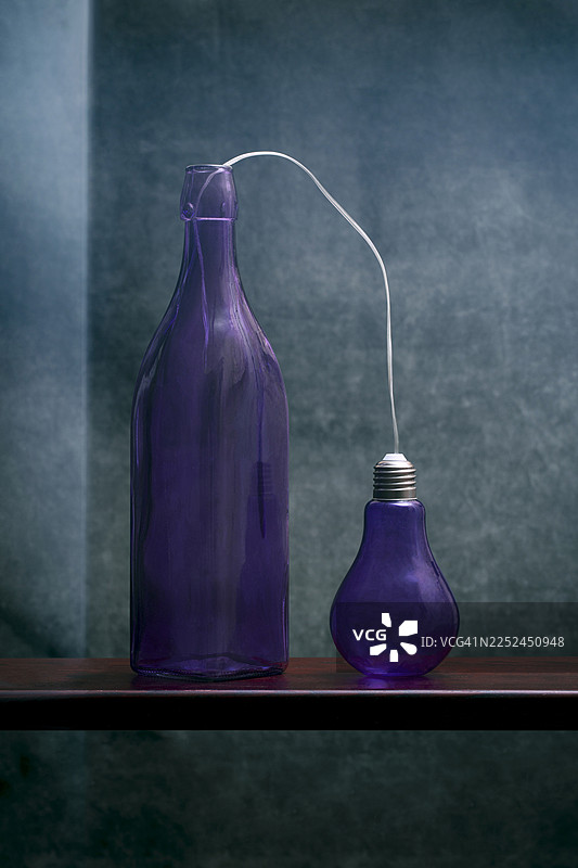 紫色瓶子和灯泡在木架上发出光芒的连接，背景是纹理蓝色图片素材