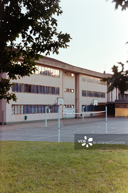 空旷的校园，有室外篮球场和排球网图片素材