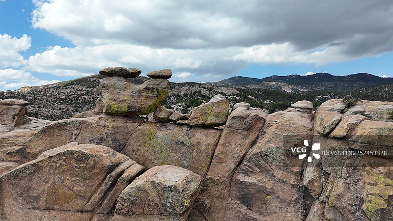 多云天空下，独特的岩石构造和山脉的全景视图图片素材
